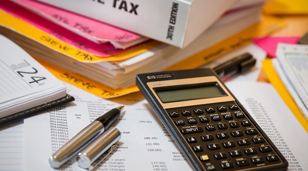 income tax documents, calendar, pen, and calculator