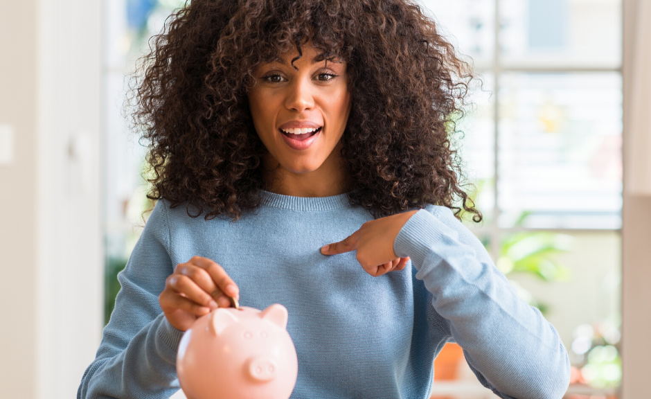 a woman with long, curly hair pointing at a piggy bank