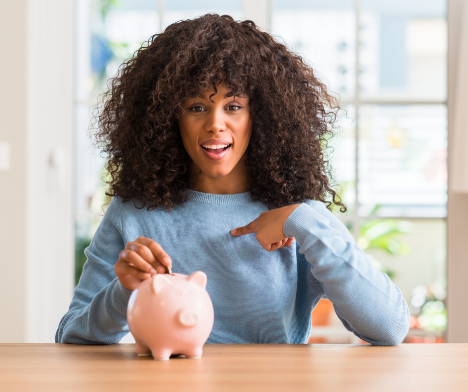 a woman with long, curly hair pointing at a piggy bank