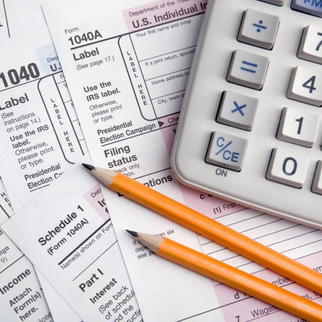 1040 and 1040A tax forms, two pencils, and a calculator