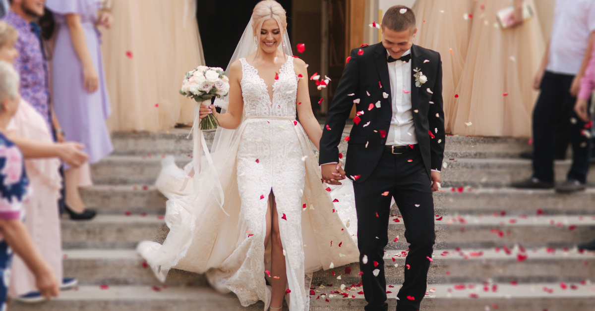 just married couple walking hand in hand, flower petals all around